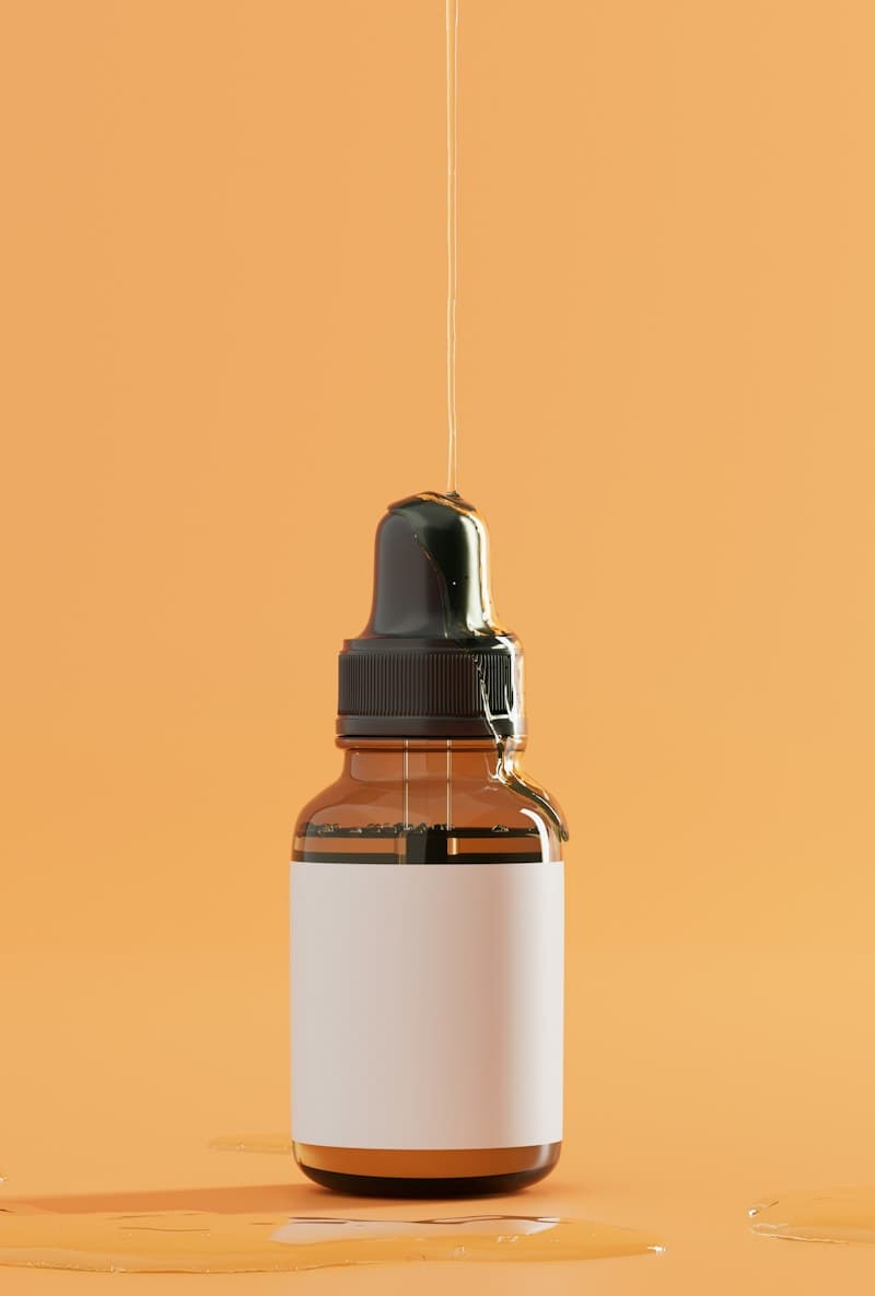 An amber dropper bottle with a blank label on an orange background