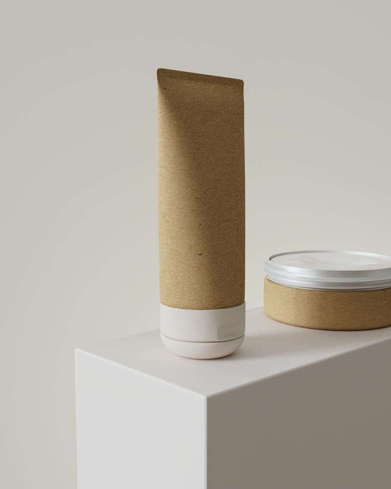 A kraft-paper tube and a matching round tin on a white plinth